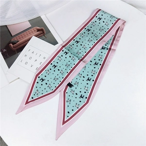 Detail view of light green twilly scarf with black polka dots and cartoon dog pattern