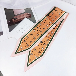 Detail of orange dog print silk scarf with green borders and sharp corner design