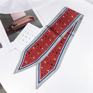 Detail of red twilly scarf with black polka dots and cartoon puppy patterns