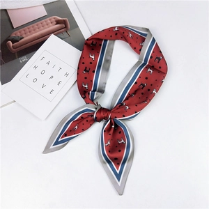 Detail of red silk scarf with dog print and contrast navy stripes tied in a bow