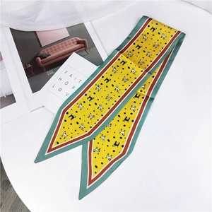 Macro detail of yellow Twilly scarf featuring cartoon dog prints and colorful borders