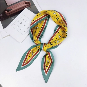 Detail of a yellow silk scarf with puppy patterns and polka dots for bag and neck styling