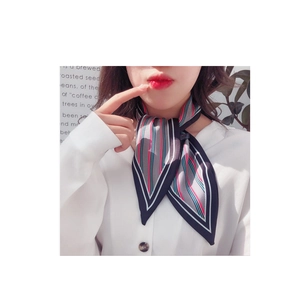 Detail of silk neck scarf with classic geometric stripes tied on neck for elegant styling