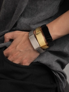Macro detail of three-color polished ID bracelets showing the smooth metal plate texture