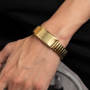 Polished gold stainless steel link bracelet with engravable bar plate on male wrist