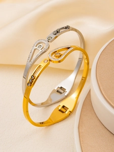 Detailed macro view of gold and silver teardrop bracelets with pavé crystal settings