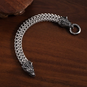 Bracelet Viking tête de loup en acier inoxydable pour homme sur surface en bois