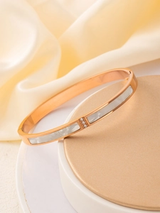 Détail du jonc en or rose avec incrustation de nacre blanche et trois petits zircons