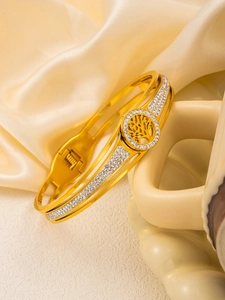 Gros plan détaillé d'un bracelet arbre de vie doré avec zircons brillants sur fond de soie