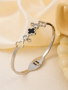 Detailed macro of stainless steel clover bracelet with black inlay and crystal accents
