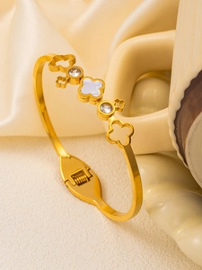 Detail of 18K gold clover bangle with white shell inlay and sparkling zirconia accents