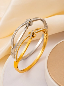Close-up of rose gold and silver crossover bow bangles with sparkling micro-pave crystals
