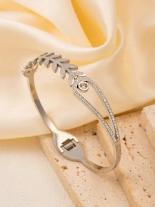 Detail of silver hinge bracelet featuring hollow leaf and diamond-set waterdrop shapes