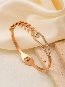Detailed macro view of a rose gold leaf bracelet with cubic zirconia and hinge clasp