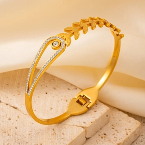 Elegant gold-plated open bangle with leaf texture and pave diamond accents on silk