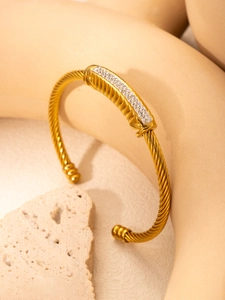 Macro detail of gold cable cuff bracelet featuring a sparkling pavé diamond rectangle bar