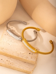 Macro detail of silver and gold twisted cable open bracelets with pavé cubic zirconia