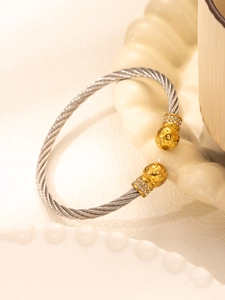 Detail of silver twisted cable bracelet with gold hammered spheres and zircon accents
