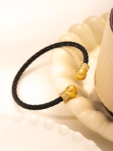 Macro shot of gold-plated twisted cable bracelet with pavé zirconia spherical ends