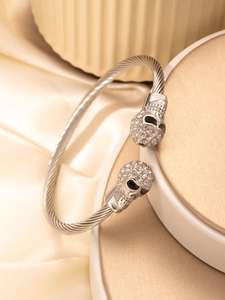 Detail of silver skull cable bracelet featuring sparkling rhinestones on textured wire