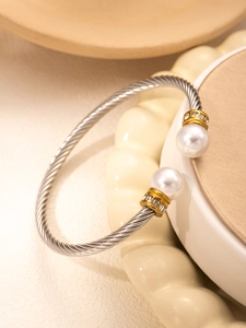 Detailed macro view of the twisted steel cable ring with pearls and pavé stones