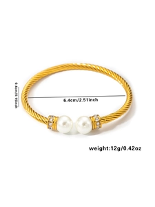 Detail of golden twisted cable bracelet with pearls and inlaid crystal accents