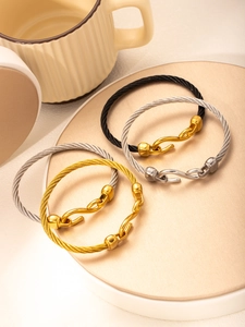 Dettaglio dei bracciali a fune d'acciaio intrecciata con chiusure metalliche a S