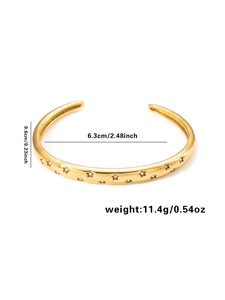 Detail view of gold star-patterned bangle showing 0.6cm width and 6.3cm inner diameter