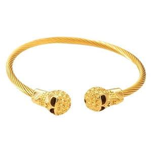 Punk style gold steel cable bracelet featuring skull charms and engraved details