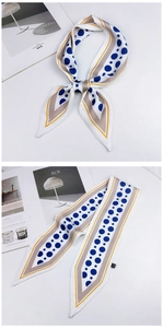Detail of a silk twilly scarf featuring blue polka dots and a yellow geometric border