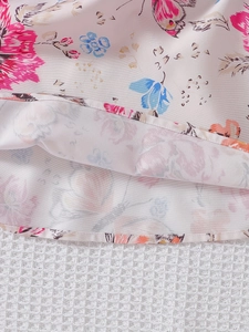 Dettaglio dell'orlo dell'abito estivo per bambine con stampe floreali e cuciture fini