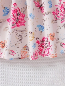 Dettaglio dell'orlo del vestito in chiffon a fiori con pieghe e stampa di farfalle