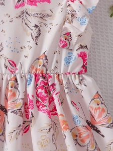 Dettaglio di un abito estivo a fiori per bambina con volant sulle spalle e cuciture precise
