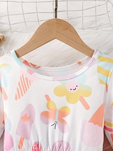 Mädchenkleid mit langen Ärmeln und Cartoon-Eiscreme-Print auf einem Holzbügel