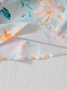 Detailed close-up of light blue floral dress hem showing premium stitching and fabric