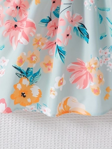 Macro detail of floral print chiffon fabric with blue background and colorful petals