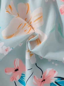 Detailed view of sky blue floral fabric showing delicate pink and white flower patterns