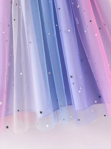 Detail of gradient rainbow tulle fabric with silver star and moon sequins on girl's dress