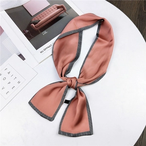 Écharpe étroite en soie rose avec bordure à chevrons noir et blanc sur fond de marbre