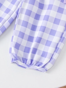 Close-up of purple gingham plaid pants with elastic ankle cuffs and fine stitching