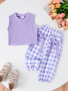 Detail of purple ribbed tank top with size label and matching plaid pants with bows