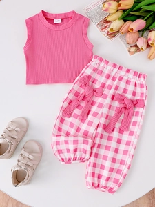 Flat lay of pink sleeveless rib-knit top and checkered trousers with bow detail