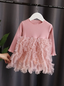 Dettaglio della gonna in tulle a strati rosa con corpino in maglia a coste e volant