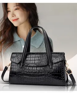 Gros plan sur la texture crocodile noire avec boucle en métal doré et bandoulière