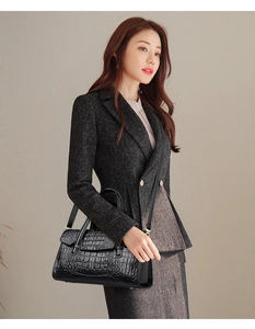 Sac à main noir à motif crocodile porté avec un costume chic pour un style professionnel