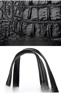 Détail de la texture cuir de crocodile noir brillant et des anses de transport solides