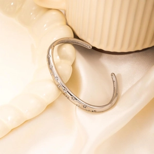Star engraved titanium steel cuff bracelet with sparkling diamonds in a luxury setting