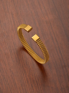 Macro shot of gold braided twisted bangle showing high-quality metal mesh texture
