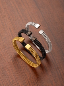 Detail view of woven stainless steel open bangles in gold, silver, and black finishes