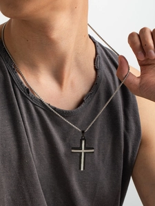 Modello maschile che indossa una collana con ciondolo a croce bicolore stile punk rock